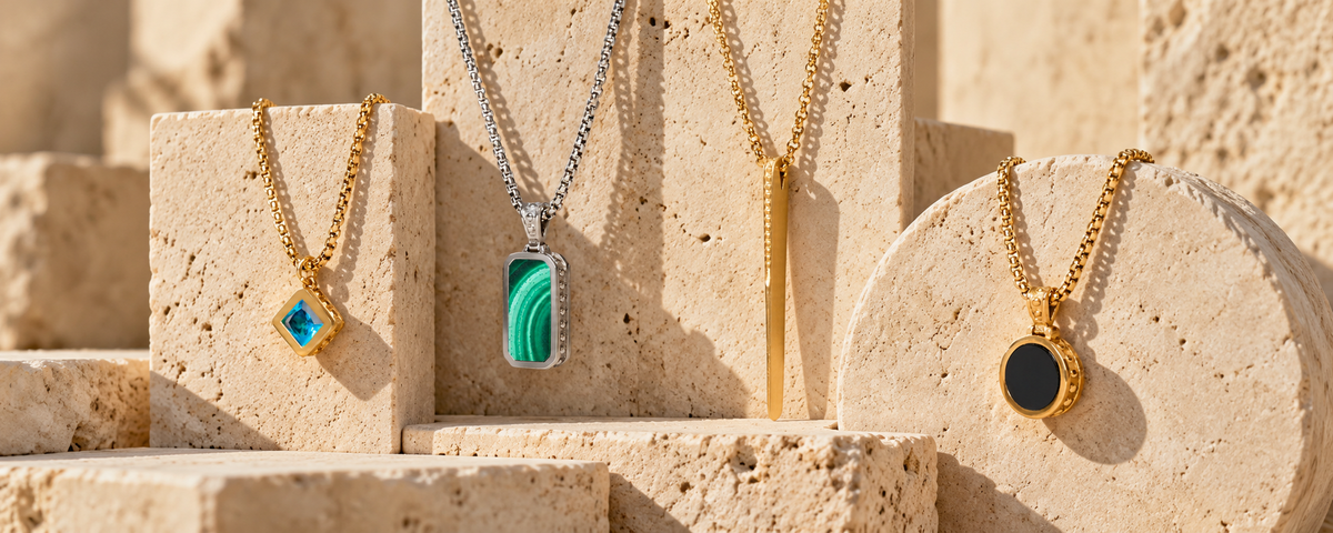 Colliers TESEO en topaze bleue, malachite et onyx, plaqué or et acier poli, sur travertin